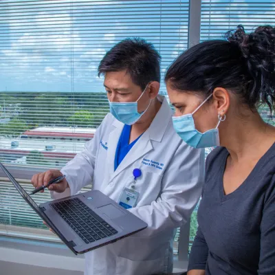 Dr. Sucundy showing a patient test results on a laptop.