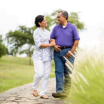 hispanic couple walking along a park path