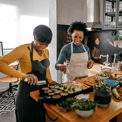 Three women preparing food in a kitchen.