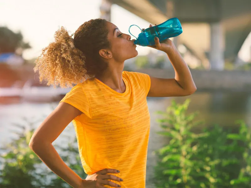 Woman on a run drinking water 