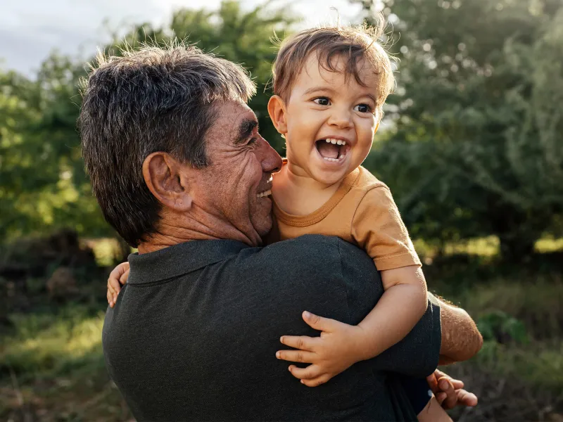 A grandfather holding his grandson.