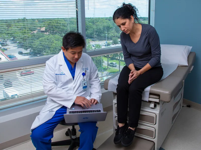 Dr. Iswanto Sucandy showing patient a something on a laptop.