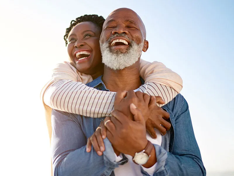 couple outdoors hugging and laughing