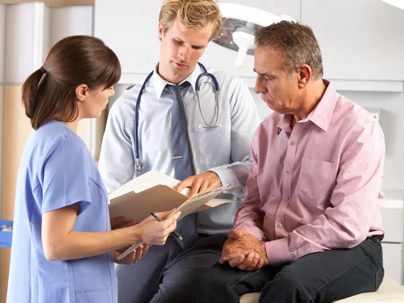 A doctor and a nurse review information with a patient.