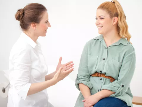 Woman discussing ongoing stomach pain with her doctor