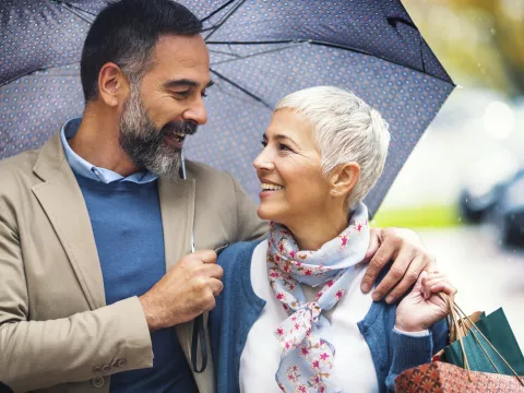 A couple takes a walk under an umbrella.