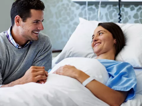 A couple holds hands while in the hospital.