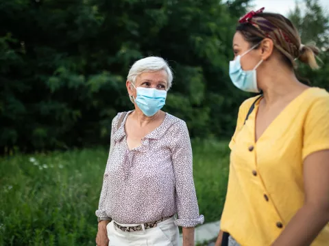 Two ladies talking while wearing masks