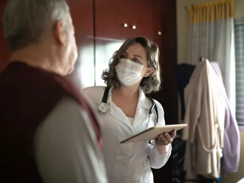 A female doctor talking to her senior patient
