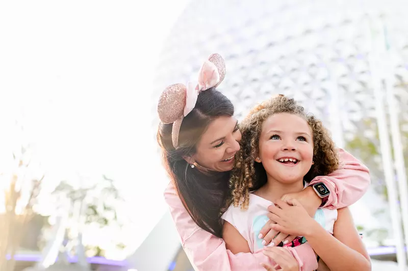 Mother and little girl standing in front of Spaceship Earth at Epcot.