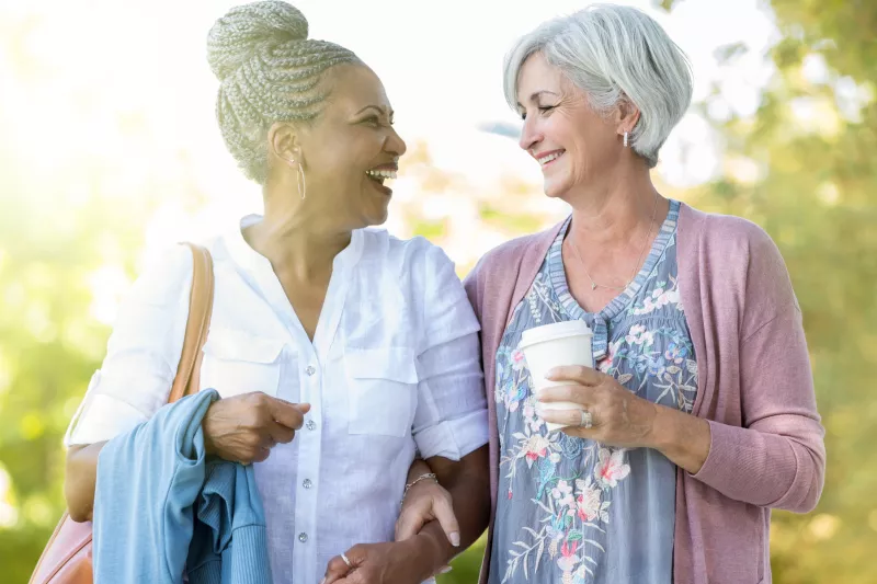 Two women walking and talking about their health.