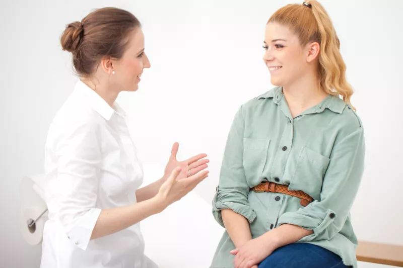 Woman discussing ongoing stomach pain with her doctor