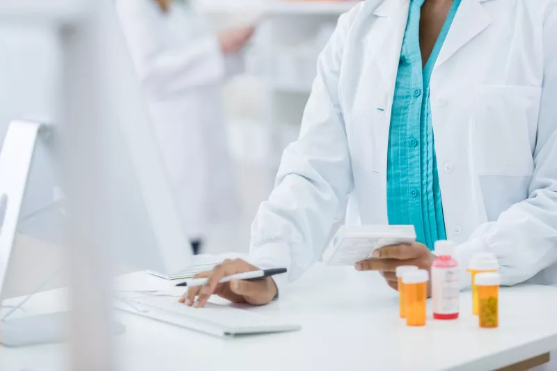 Female pharmacist on a computer.