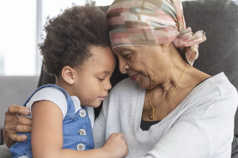 A cancer survivor hugs her grandchild.