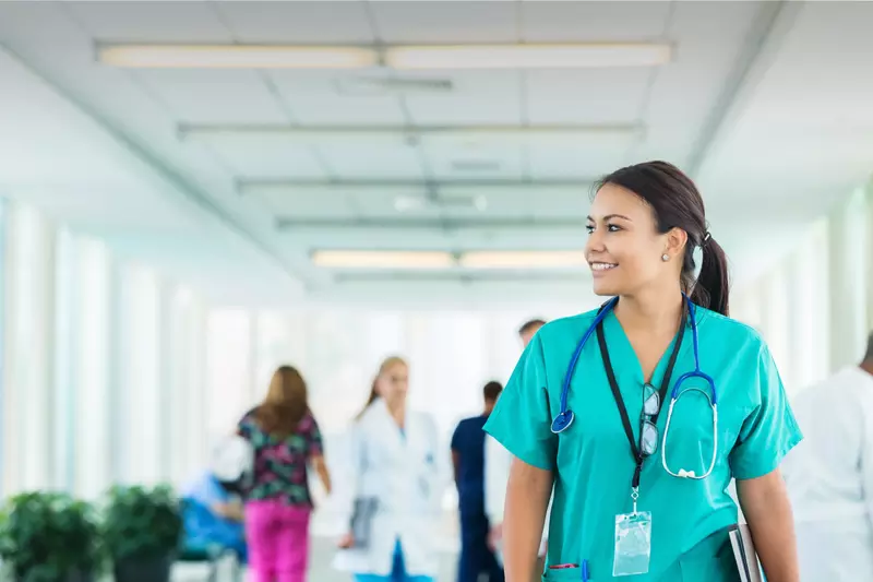 Female health care professional walking down hospital hallway