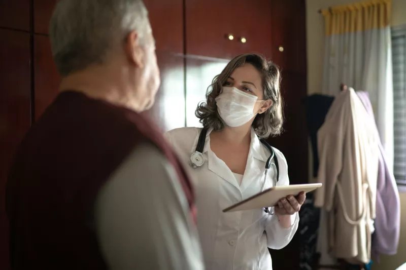 A female doctor talking to her senior patient