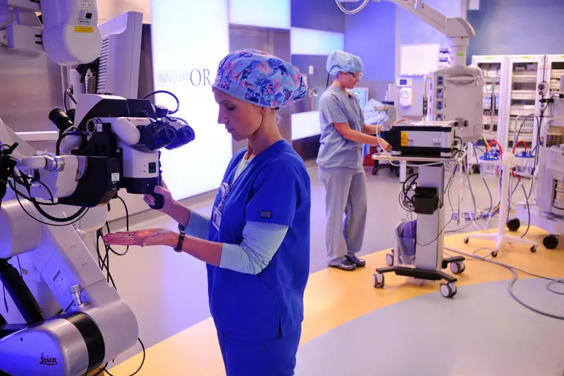 Medical specialists work with robotic surgery equipment.