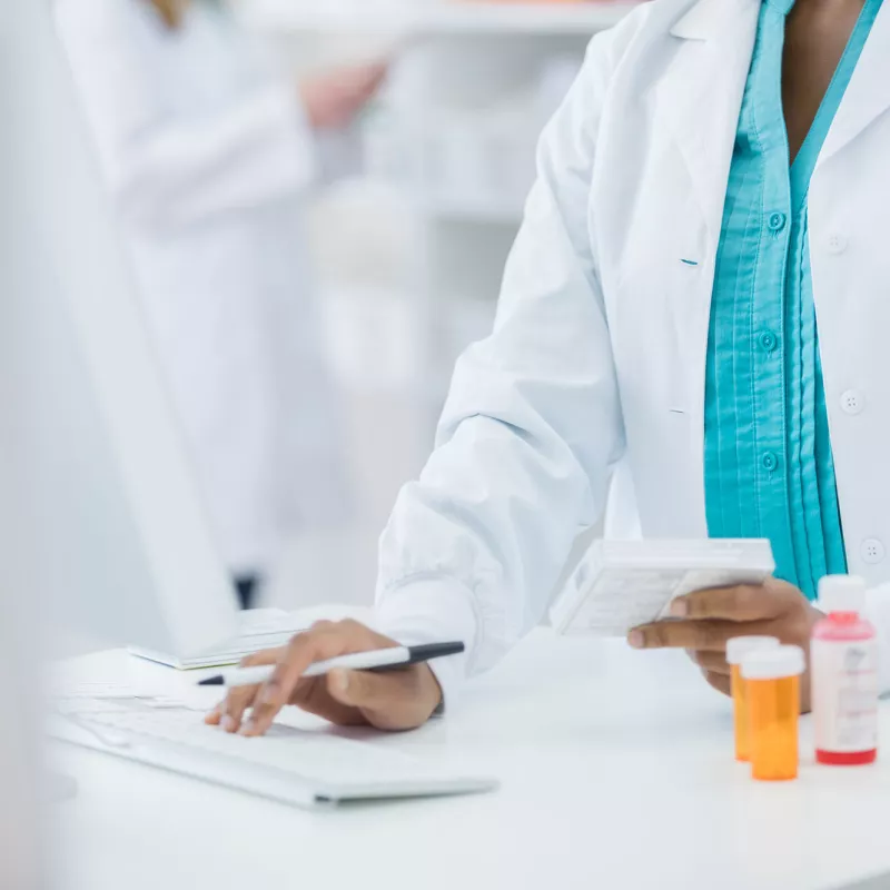 Female pharmacist on a computer.