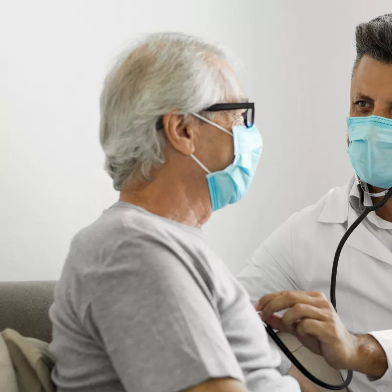 A doctor listening a patient's heart.