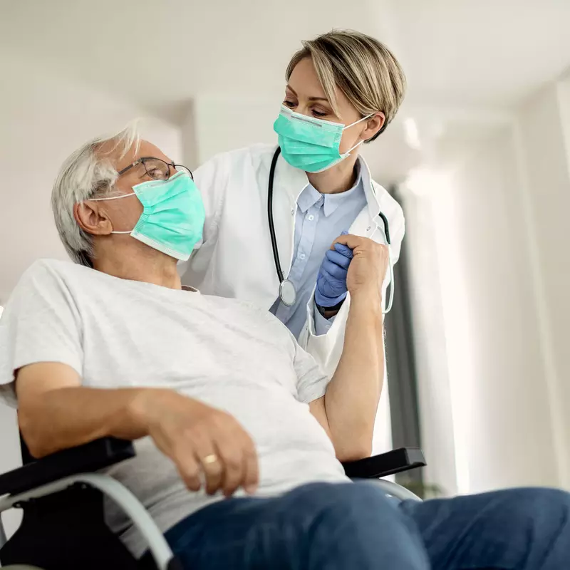 A doctor helping her senior patient on a wheelchair