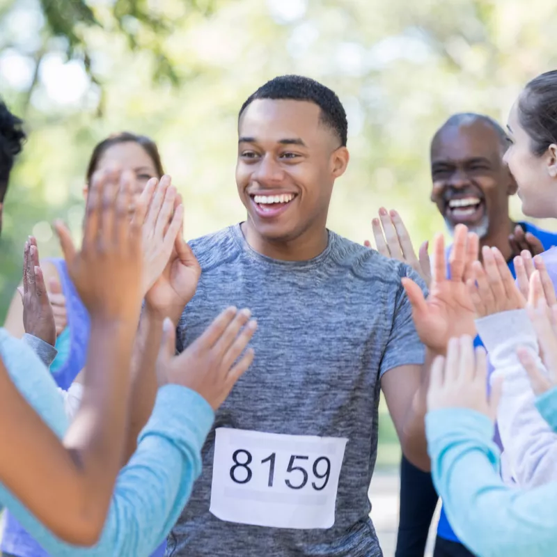 A happy runners gets a high five after finishing a race.