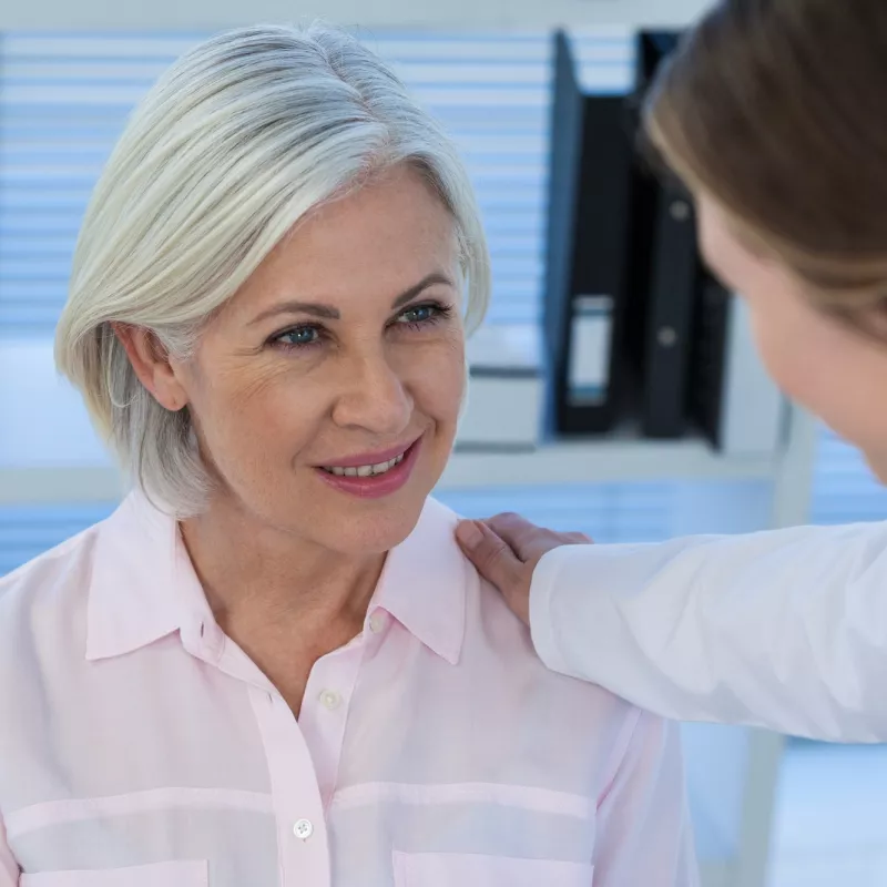 A woman talks with her doctor before an imaging test.