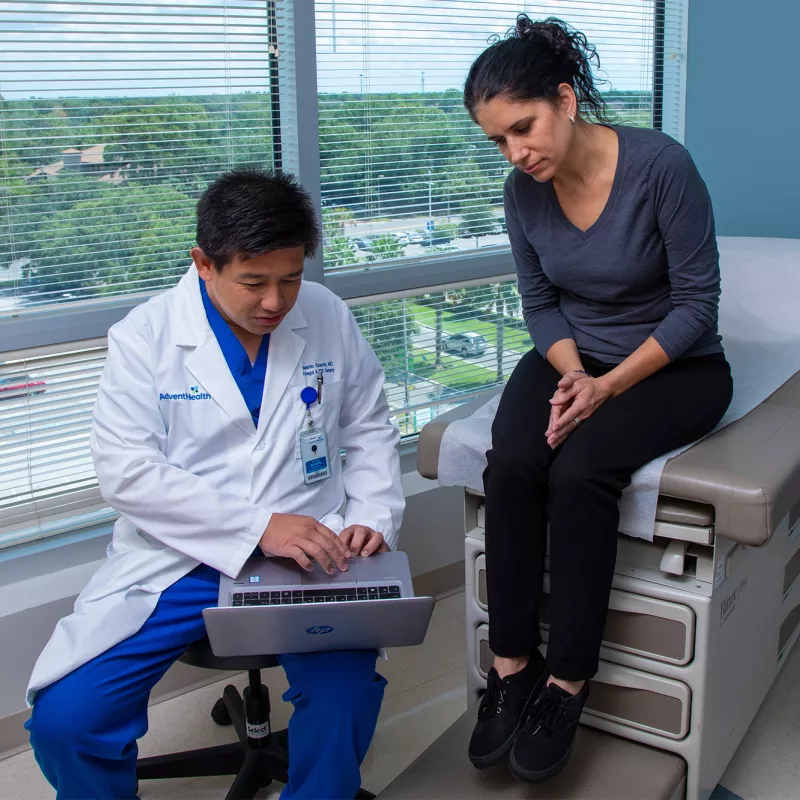 Dr. Iswanto Sucandy showing patient a something on a laptop.