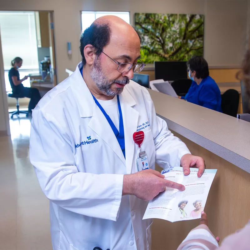 Yasser Saloum showing patient informational brochure.