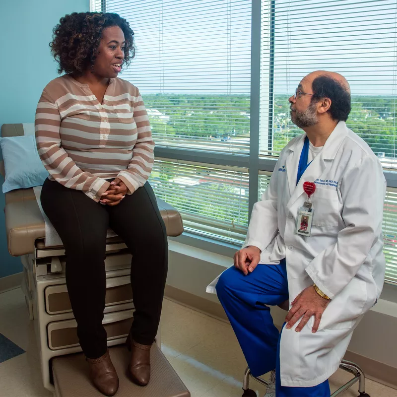 Doctor Yasser Saloum talking with patient at an appointment.