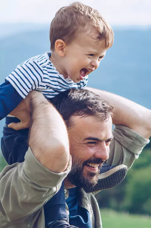 A Father and Son Laugh and Play in the Mountains