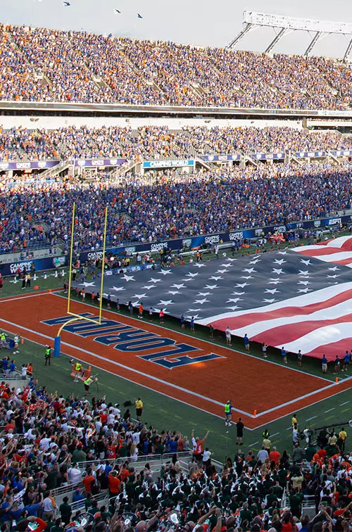 In the stands, looking over as the American flag is stretched over the field at Camping World Stadium.